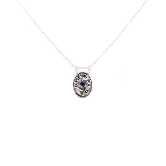 Hunt Of Hounds Forget Me Not Necklace. Text surrounding a flower set with sapphire.