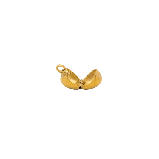 Gold pendant shaped like an apple on a white background