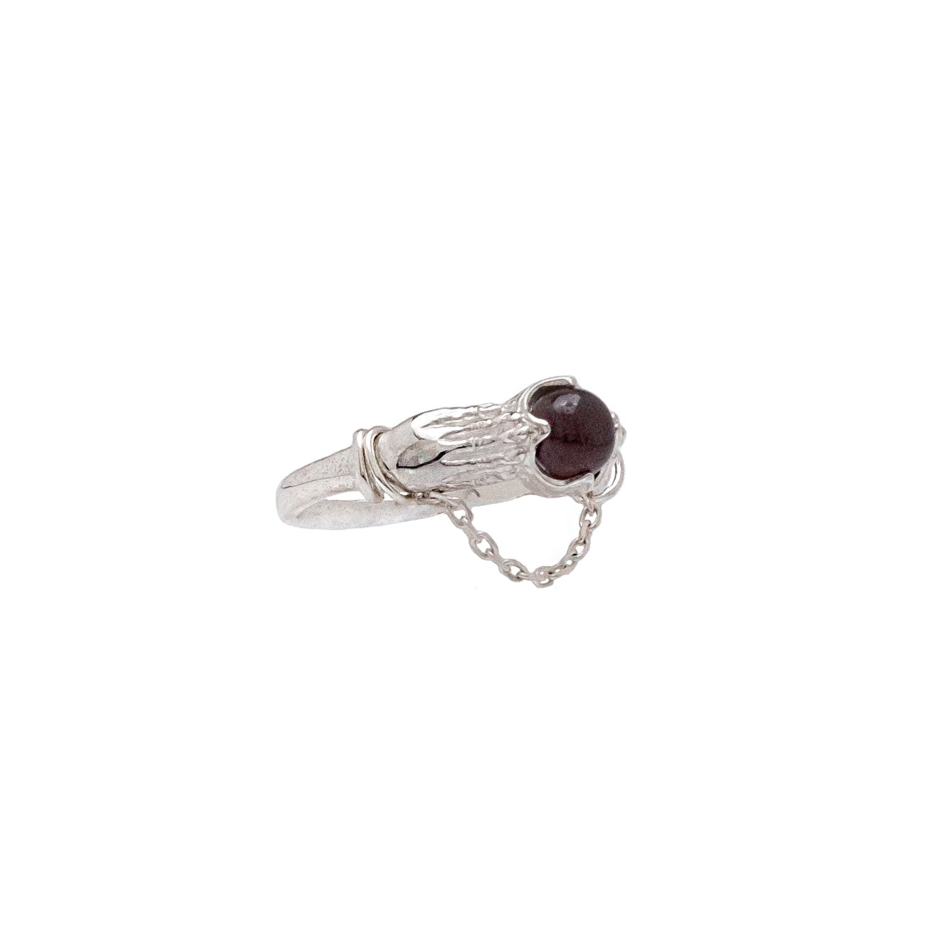 Silver ring with a dark red gemstone on a white background