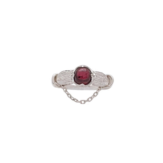 Silver ring with a red gemstone on a white background