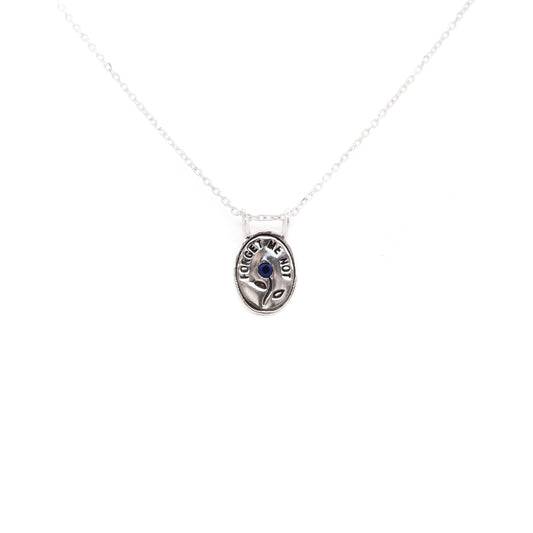 Hunt Of Hounds Forget Me Not Necklace. Text surrounding a flower set with sapphire. 